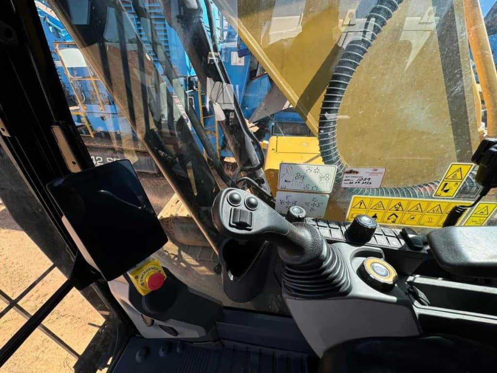 Engine compartment of the 2022 Caterpillar 323 Excavator with service panels open showing the Cat C7.1 engine and hydraulic components