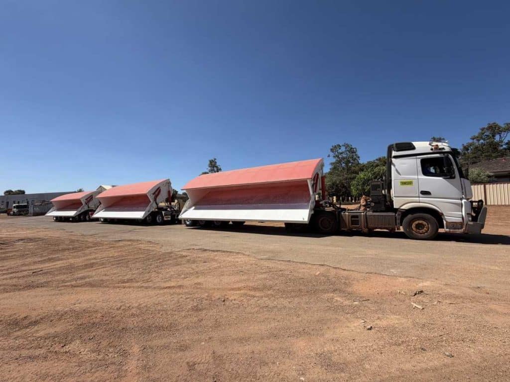 FreightWest triple side tipper trailers with their tipper bins in an open, raised position attached to a prime mover truck