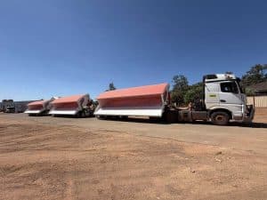 FreightWest triple side tipper trailers with their tipper bins in an open, raised position attached to a prime mover truck