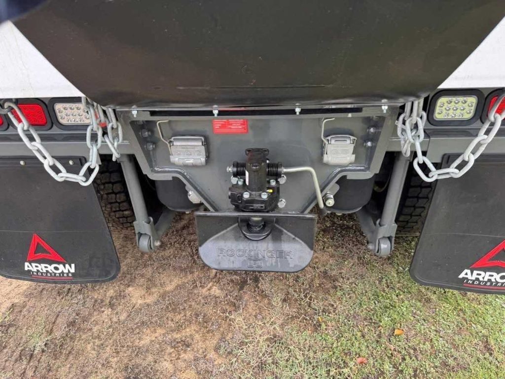 Close-up view of the rear tow hitch coupling and mudflaps at the back of the tipper chassis.